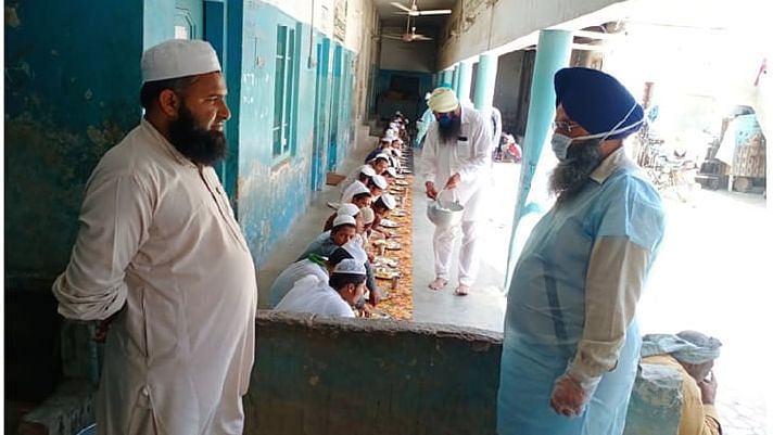 Volunteers from Gurdwara Haa Da Naara feeding Madrasa students in Malerkotla