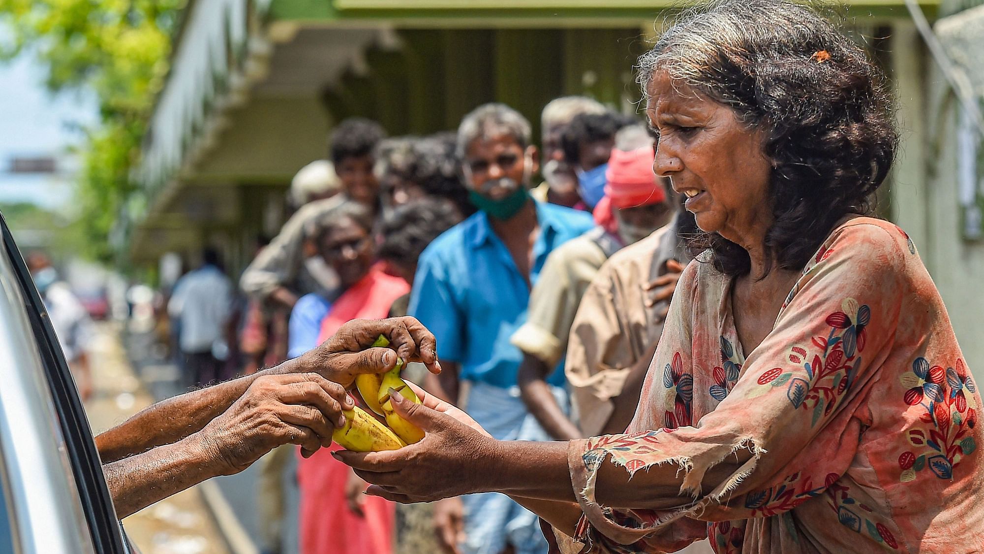 People receive food distributed by volunteers during the nationwide lockdown, imposed as a preventive measure against the coronavirus pandemic, in Chennai, Monday, April 27, 2020.  &nbsp;