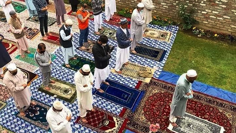 People offering Eid prayers while maintaining social distancing.