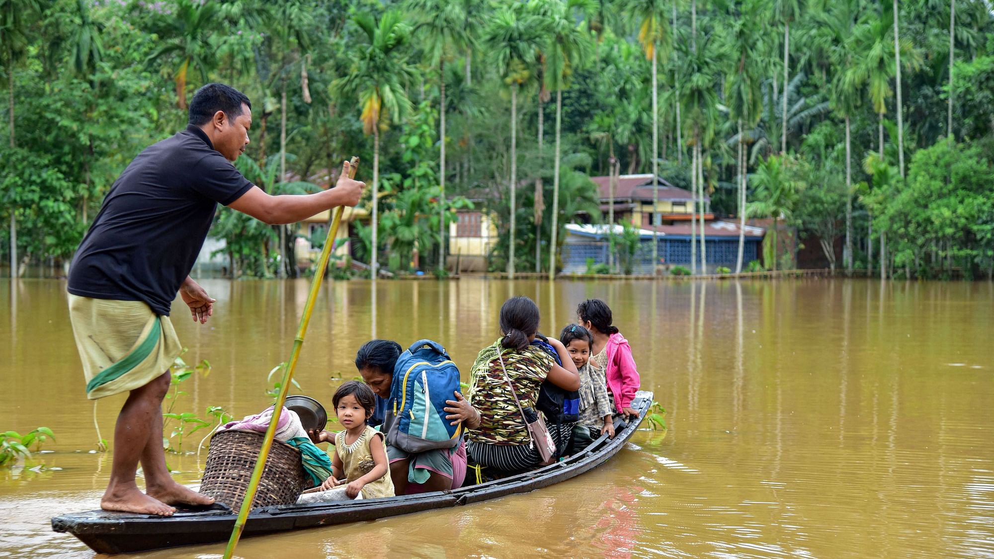 Villagers use a country boat to shift from a flooded locality following heavy rainfall in Goalpara district of Assam, on Monday, 25 May. Heavy rainfall caused flooding in hundreds of villages in Lower Assam.