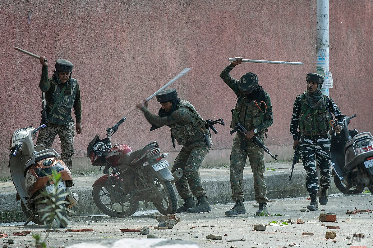 Indian paramilitary soldiers break motorbikes parked outside a college as they clash with students protesting in Srinagar against the rape of a 3-year-old child.