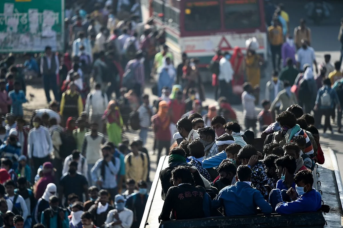 Migrants board a crowded bus to their native village, during a nationwide lockdown imposed in the wake of coronavirus pandemic, in Ghaziabad, Saturday, 28 March 2020.