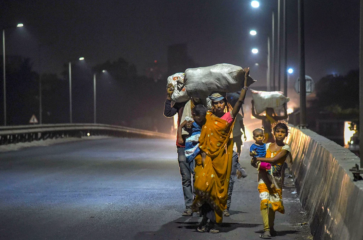A migrant family from Madhya Pradesh walks along a road to reach home in Navi Mumbai, late Sunday night.
