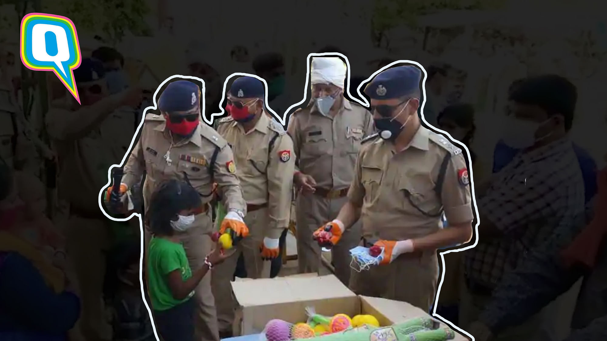 Jhansi Police officers distributing masks and toys to migrant children.