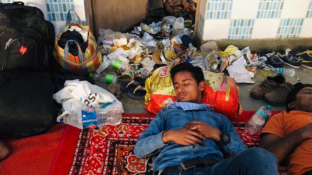 A migrant worker who wants to return to Bihar sleeps next to a mounting pile of dirt in a hall where migrant workers are asked to stay in Uttar Pradesh Ghaziabad district.&nbsp;