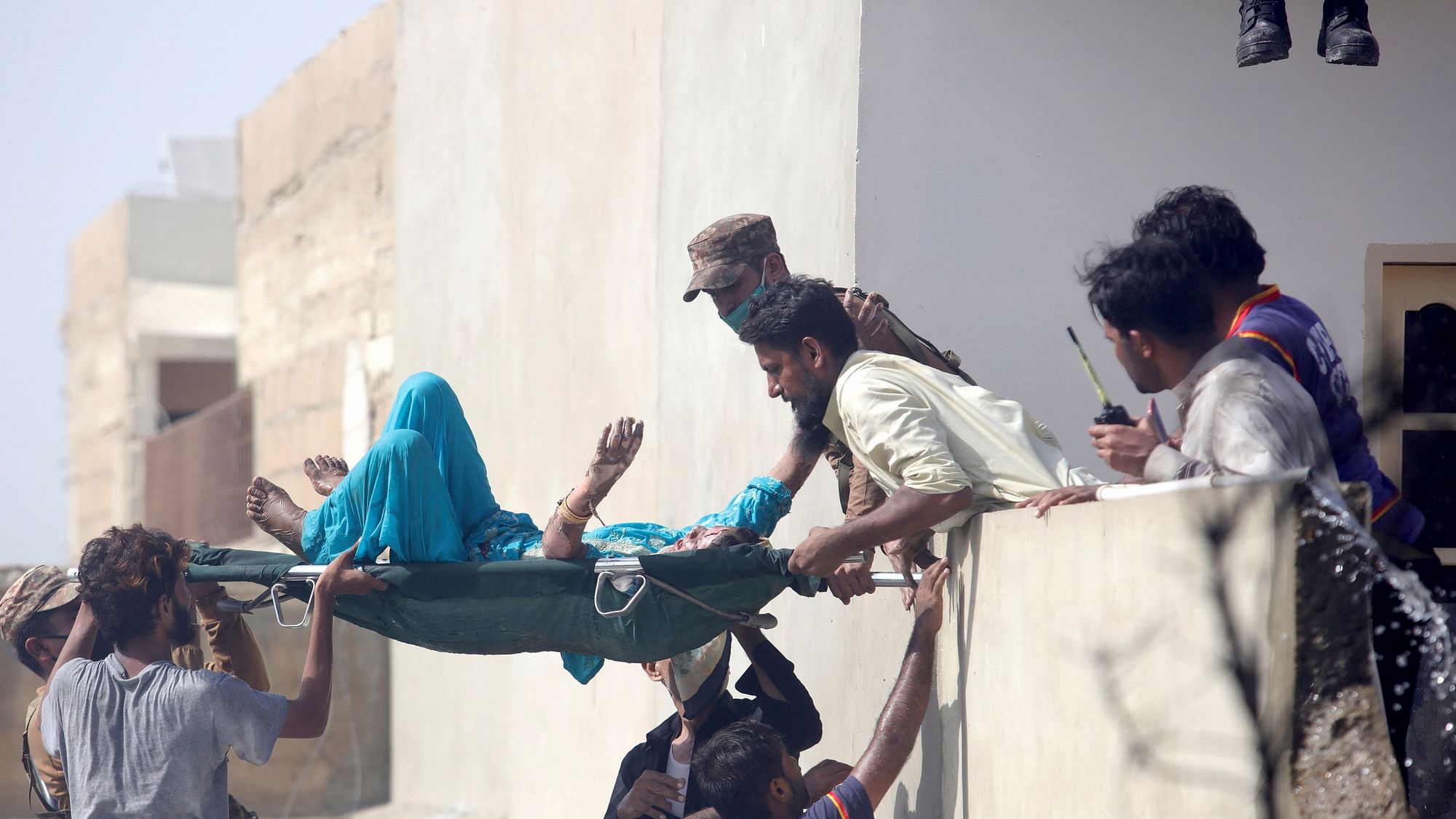 Volunteers carry an injured person at the site of a plane crash in Karachi, Pakistan, on 22 May.&nbsp;