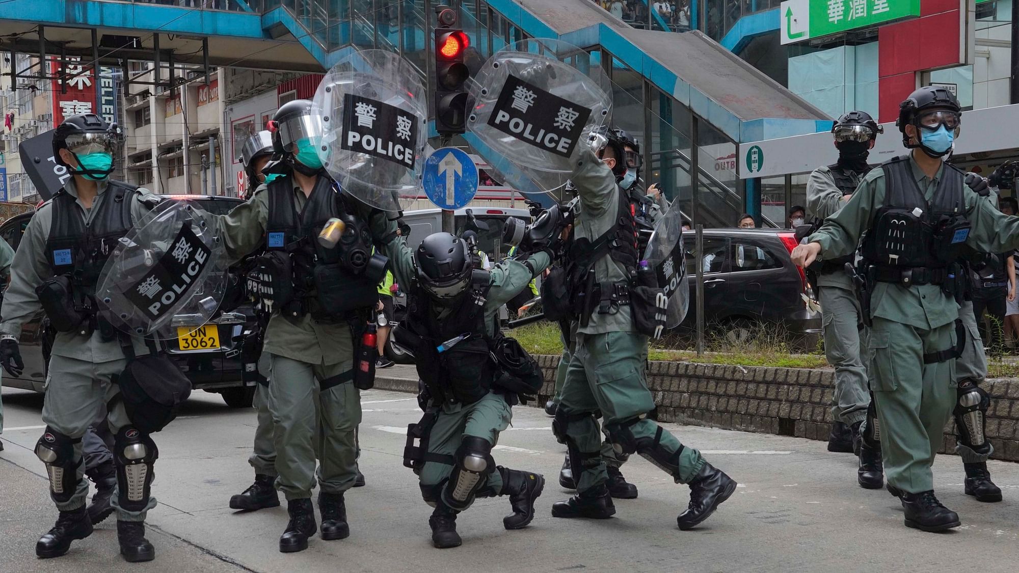 Riot police cover themselves with shields as hundreds of protesters march along a downtown street during a pro-democracy protest against Beijing's national security legislation in Hong Kong, Sunday, 24 May 2020.