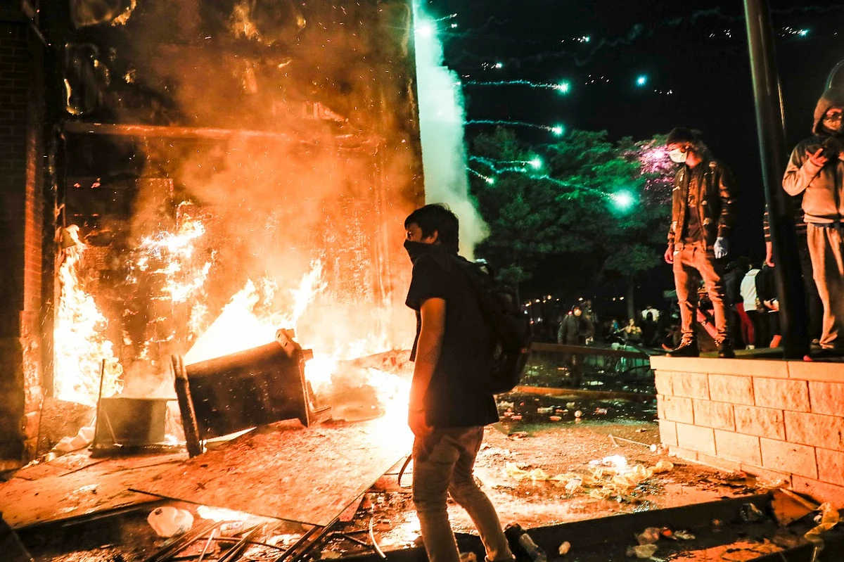 Protestors demonstrate outside of a burning Minneapolis 3rd Police Precinct, Thursday, 28 May 2020, in Minneapolis. 