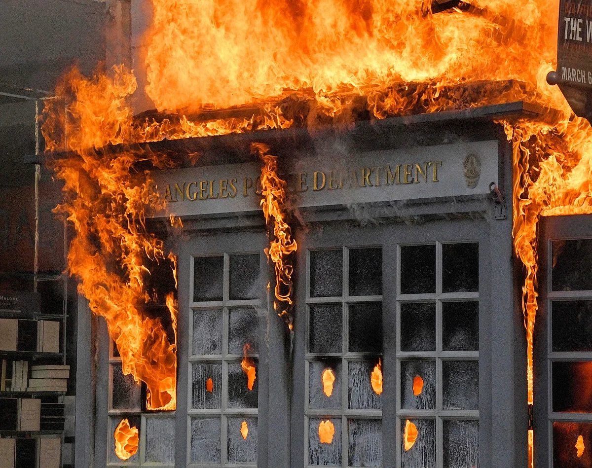 A Los Angeles Police Department kiosk is seen ablaze in The Grove shopping centre during a protest over the death of George Floyd, Saturday, 30 May 2020. Protests were held in US cities over the death of Floyd, a black man who died after being restrained by Minneapolis police officers on 25 May.