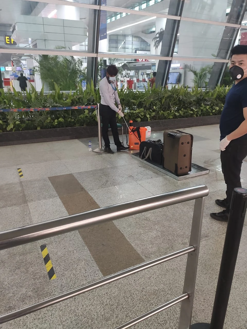 The airport staff were spraying disinfectants on the luggage at the Delhi airport.