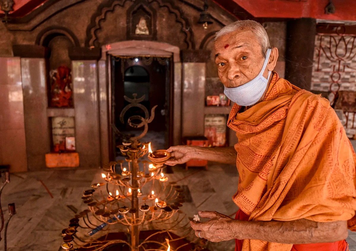 A priest offers prayers at Ugratara temple after the authorities permitted opening of all religious places with certain restrictions, during the fifth phase of the ongoing COVID-19 lockdown, in Guwahati.