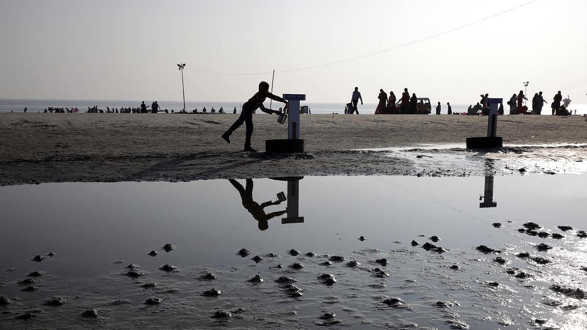 An Indian boy collects drinking water from a tap on the bank of Bay of Bengal