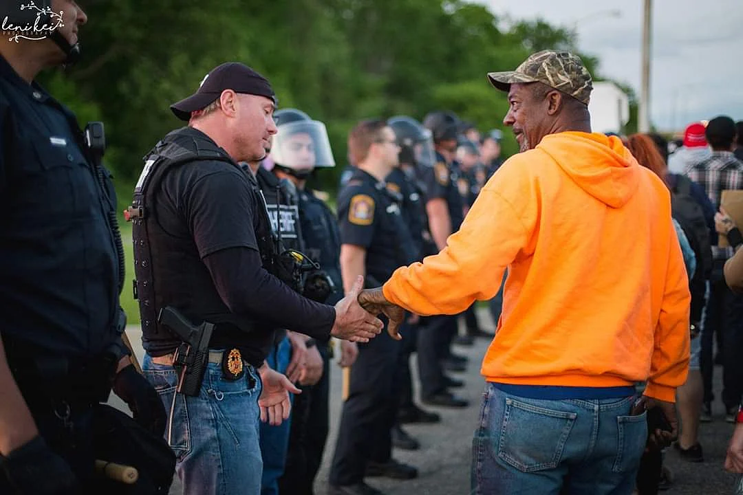 Policemen stand in solidarity with protesters in US.