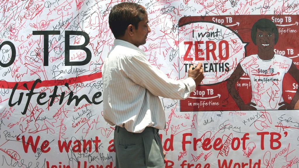 A volunteer signing the signature campaign poster during a TB awareness program, for eradication of TB in India.
