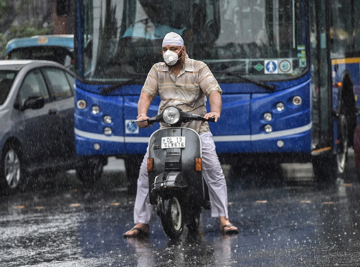 A scooterist stuck in traffic during pre-Monsoon rainfall, in New Delhi, Wednesday, 24 June.