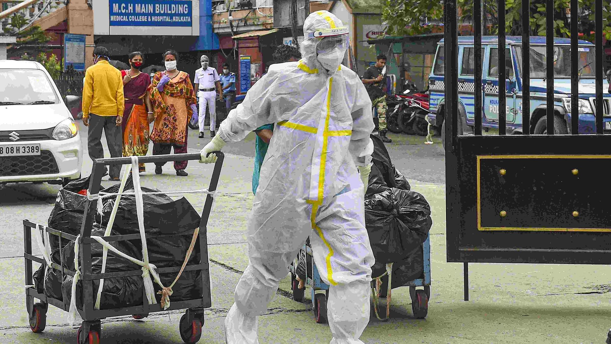 A health worker carries medical waste for disposal at Calcutta Medical College Hospital in Kolkata on 16 June.&nbsp;