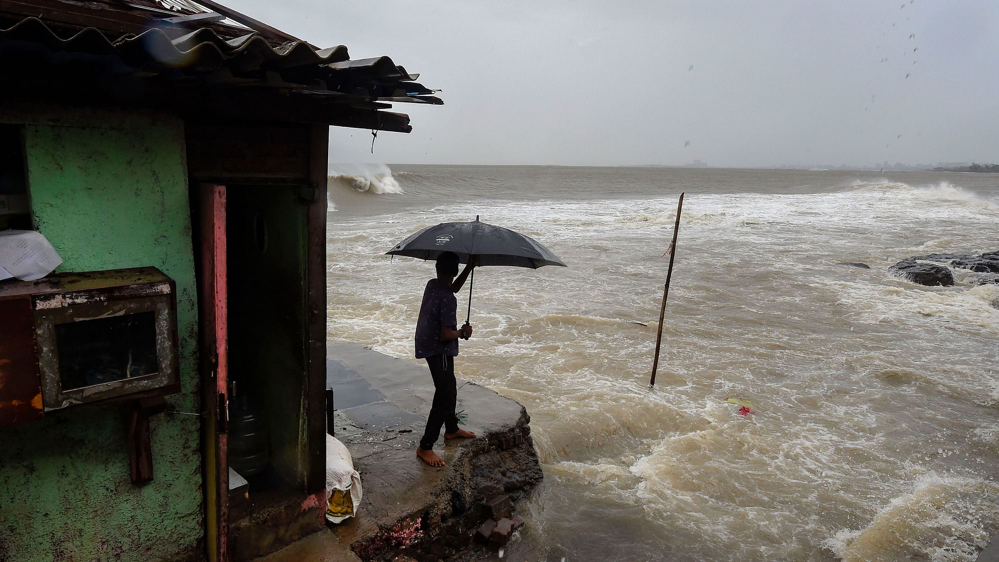 A man stands near a shanty built on the edge of the Arabian Sea at Bandra, Mumbai ahead of Cyclone Nisarga.
