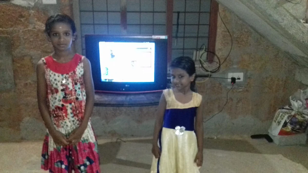 Anamika and her sister pose with the TV donated by Fr. Chiramel. 