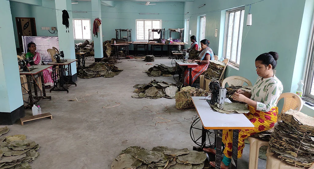 Women stitching sal leaf plates on sewing machines at the Jhargram center