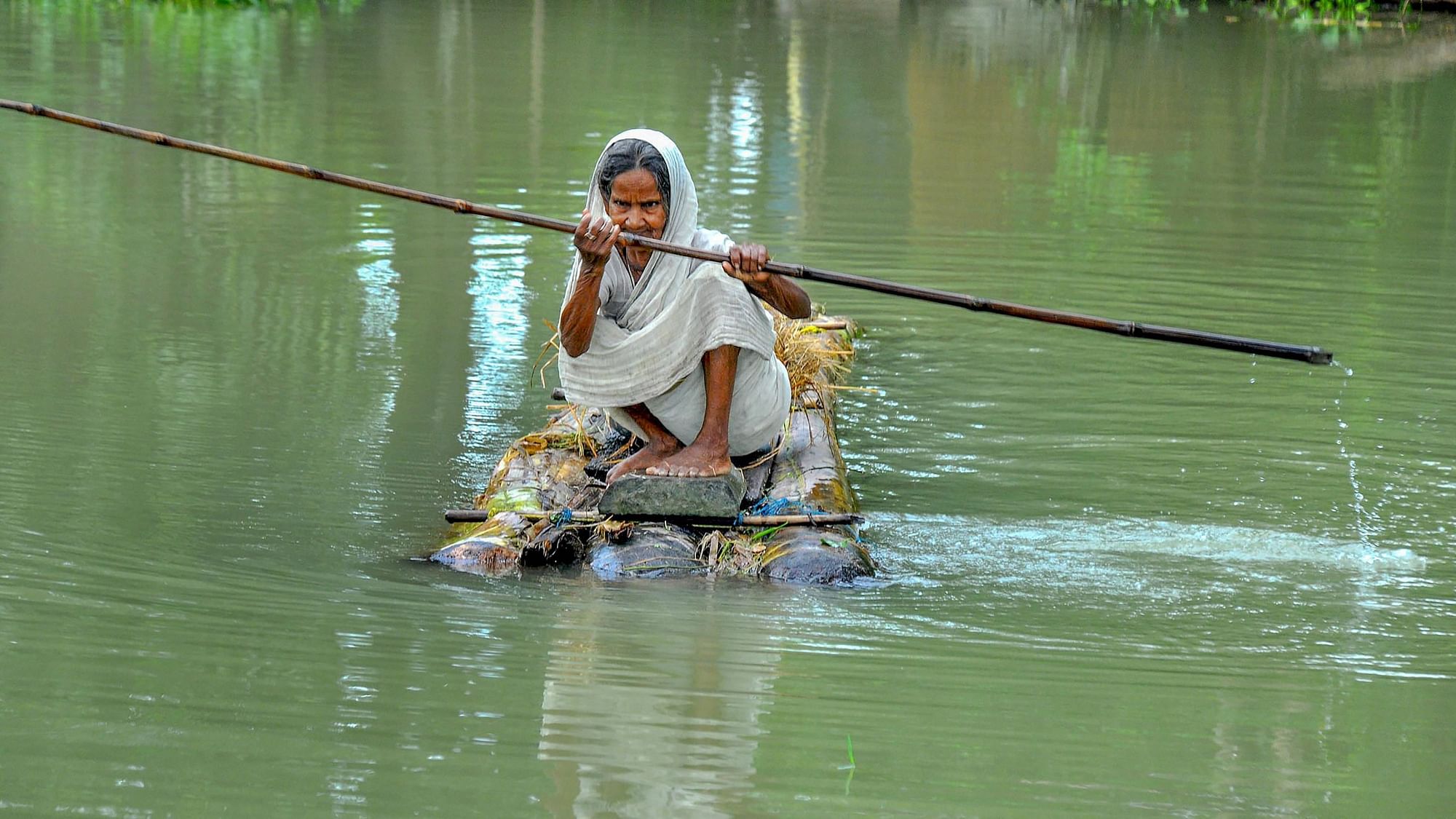<div class="paragraphs"><p>An elderly woman rows a makeshift raft to cross a flood-affected area in Assam.</p></div>
