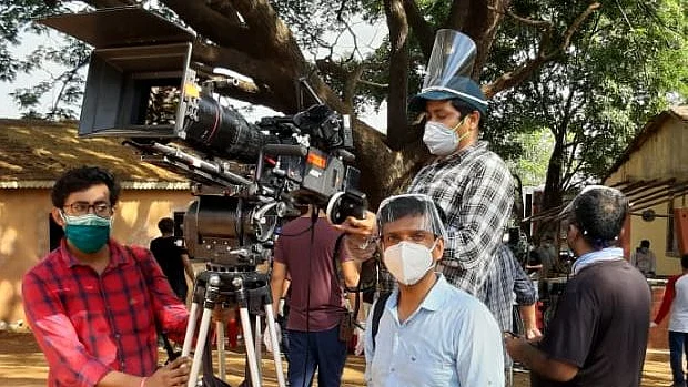 The cast and crew wear masks while shooting for an ad.