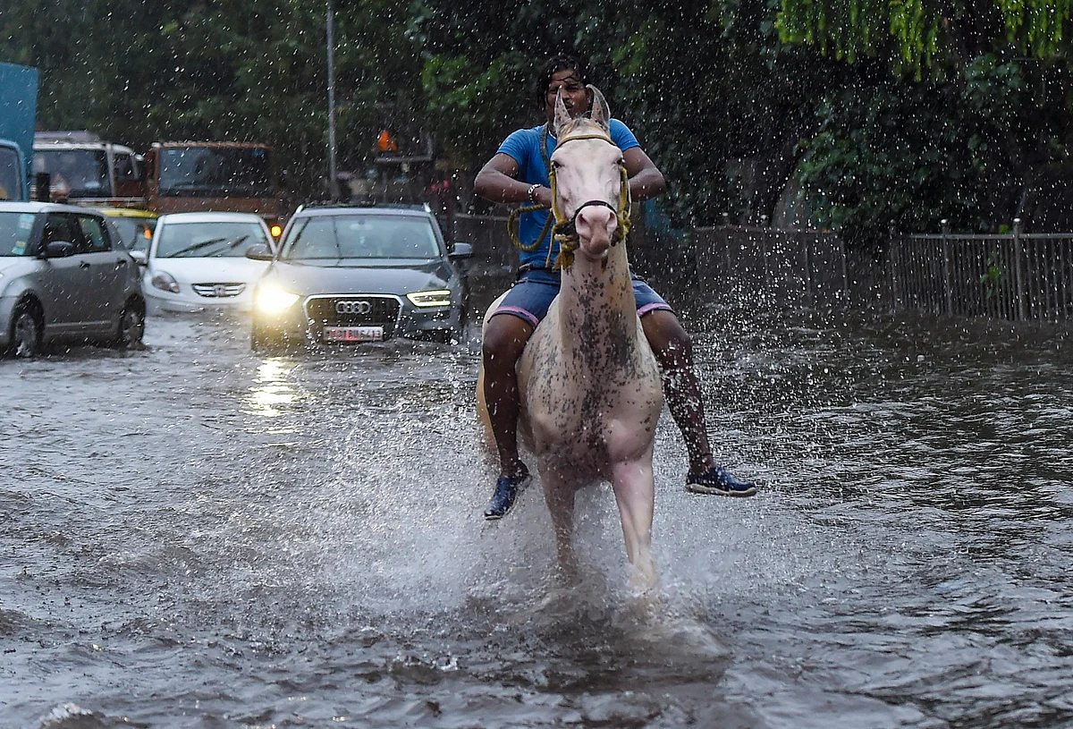 A man rides a horse on a water-logged street in Sion.
