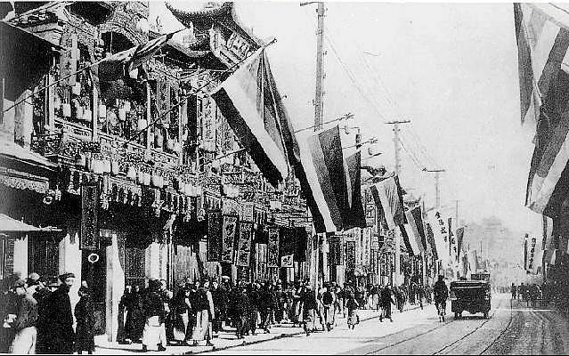 Chinese Revolution of 1911 aka the Xinhai Revolution in Shanghai-Nanjing Road (Nanking Road) after the Shanghai Uprising, hung with the Five Races Under One Union flags then used by the revolutionaries in Shanghai and Northern China. Archival Image.