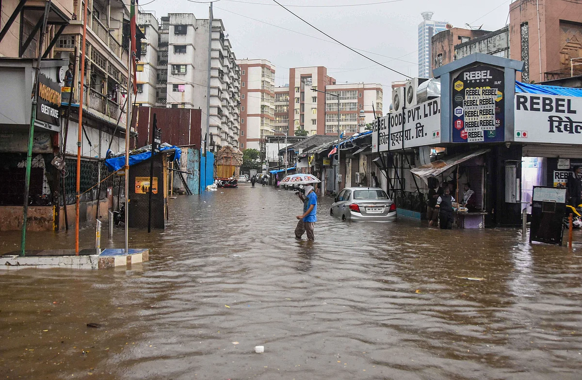 A commuter crosses a water-logged street in Parel, Mumbai.