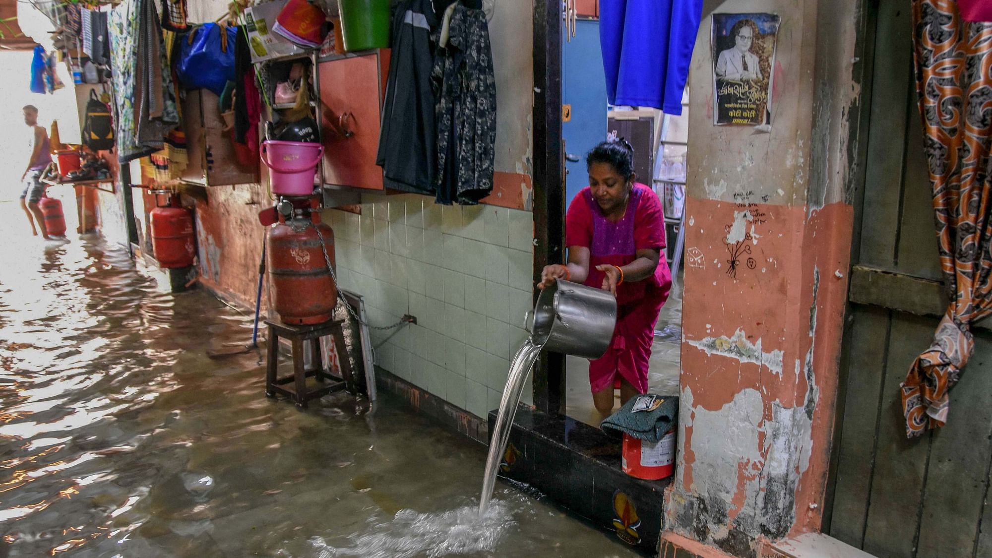 A woman drains water from her house in Parel, Mumbai.