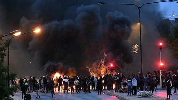 Smoke billows from burning tyres and pallets and fireworks as a few hundred protesters gather in the Rosengard neighbourhood of Malmo, Sweden.<b></b>