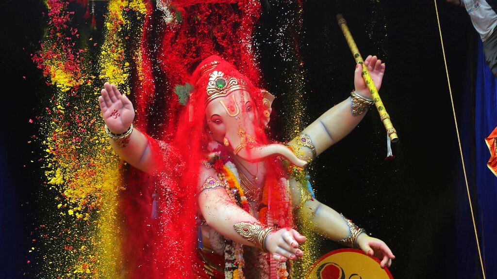 Turmeric and vermilion powder are poured on a giant idol of Lord Ganesha as it is taken for immersion on the tenth day of the ten-day long Ganesh Chaturthi festival in Mumbai, on Thursday, 12 September 2019.&nbsp;