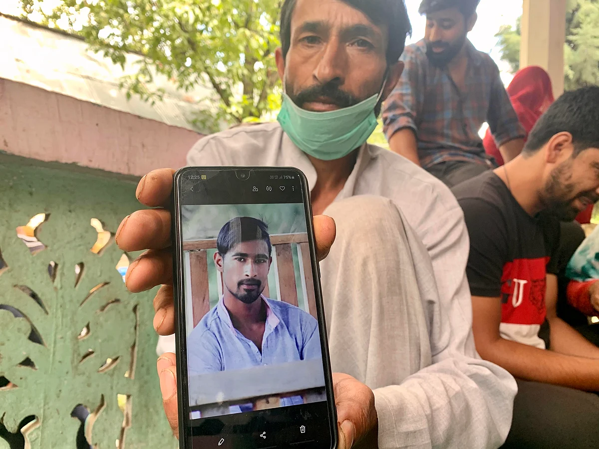 Farooq Wani, father of Umer Wani, one of the students arrested by J&K police in the anti-terror case, holding up his son’s photo.