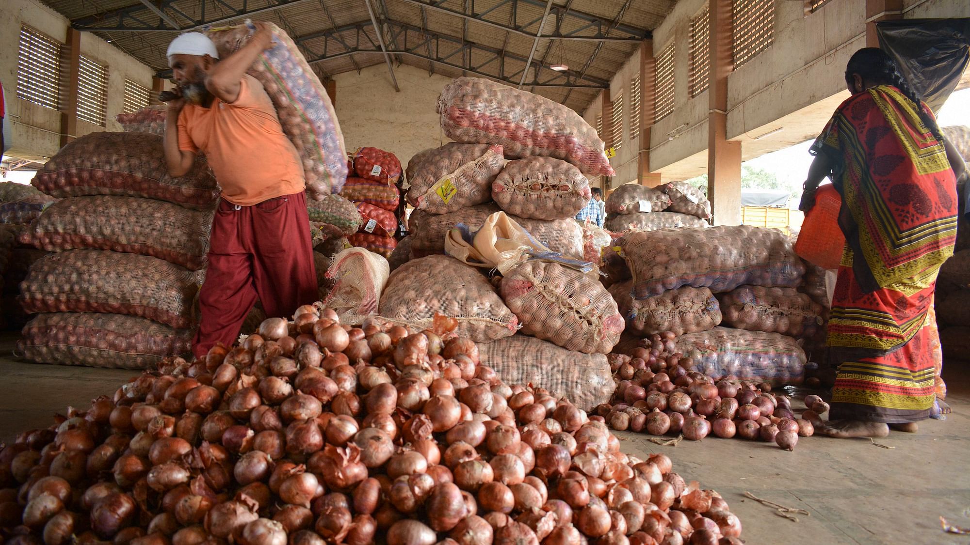 Sacks filled with onions at a market, in Karad.
