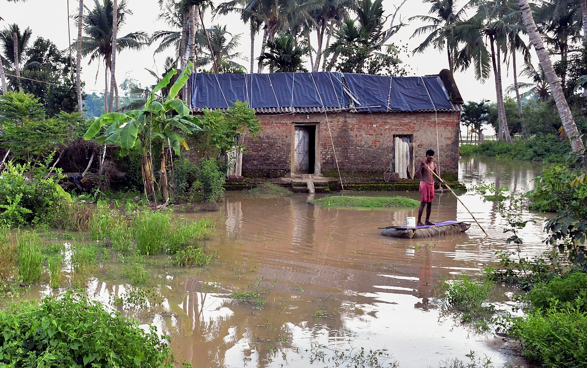 A villager rows a boat in a flooded area following overflowing of Bhargabi river, in Puri district.