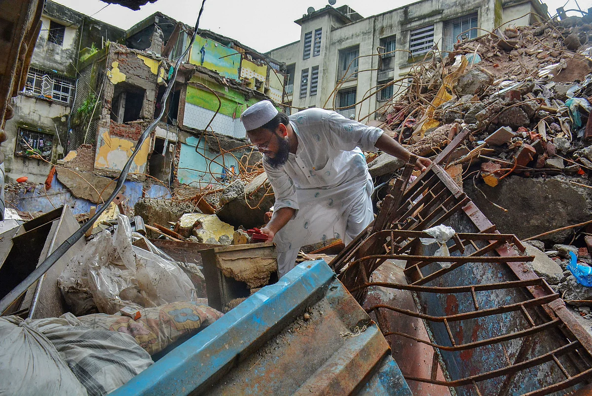 A resident looks for some households amid the debris at the building collapse site after completion of rescue works by NDRF and Fire Brigade personnel, at Bhiwandi in Thane, Thursday, 24 September.