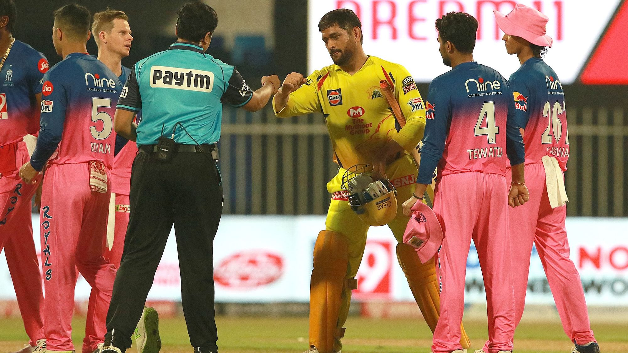 Chennai Super Kings captain MS Dhoni fist bumps the umpire as Rajasthan Royals Captain Steve Smith looks on.&nbsp;
