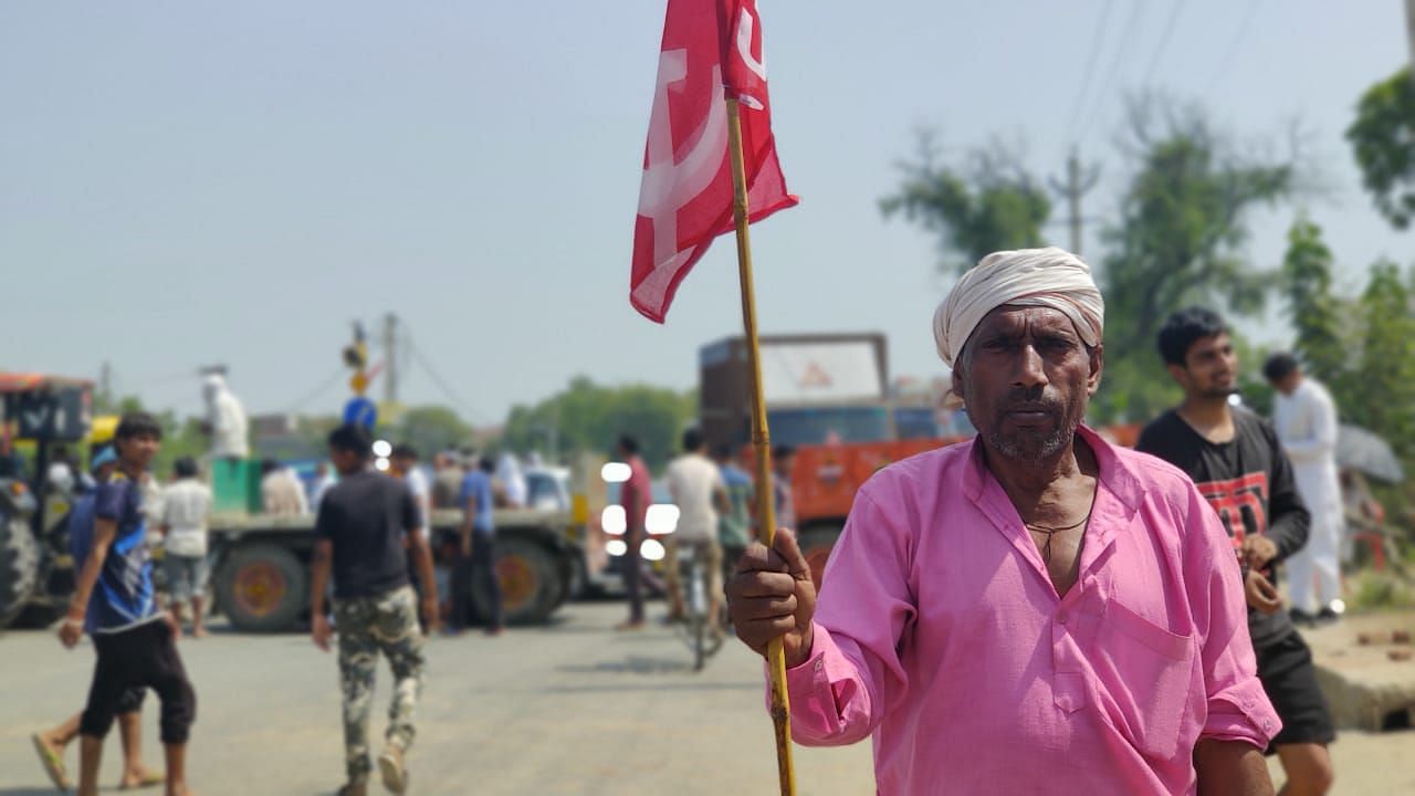 A fermer holds a flag in a protest rally in Haryana’s Mahem.