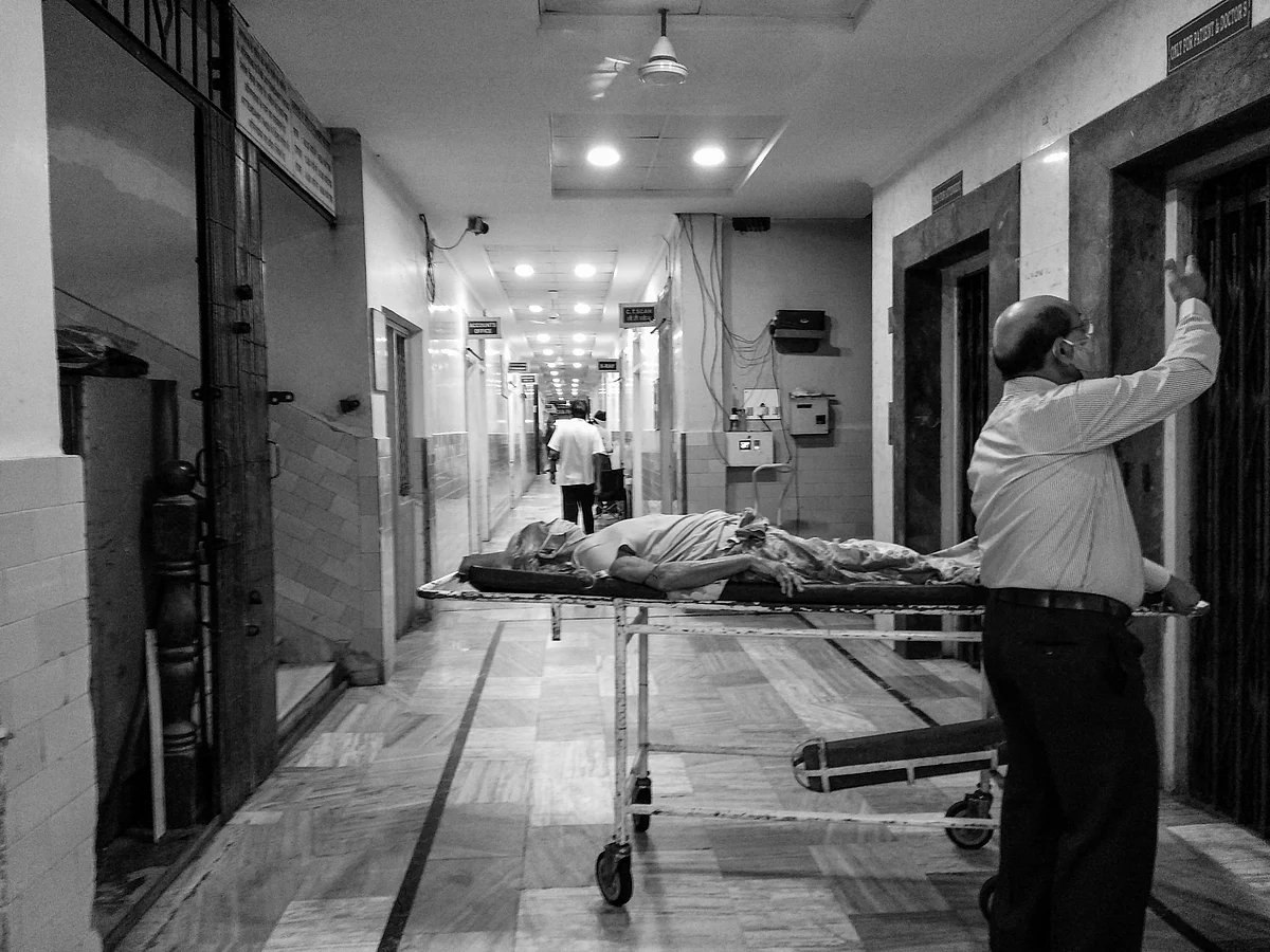 An old man waits for the lift to carry the patient.