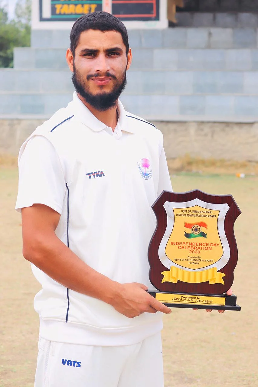 Shabir ‘Lefty’ posing with the ‘Promising Cricketer Award’ at Pulwama Stadium