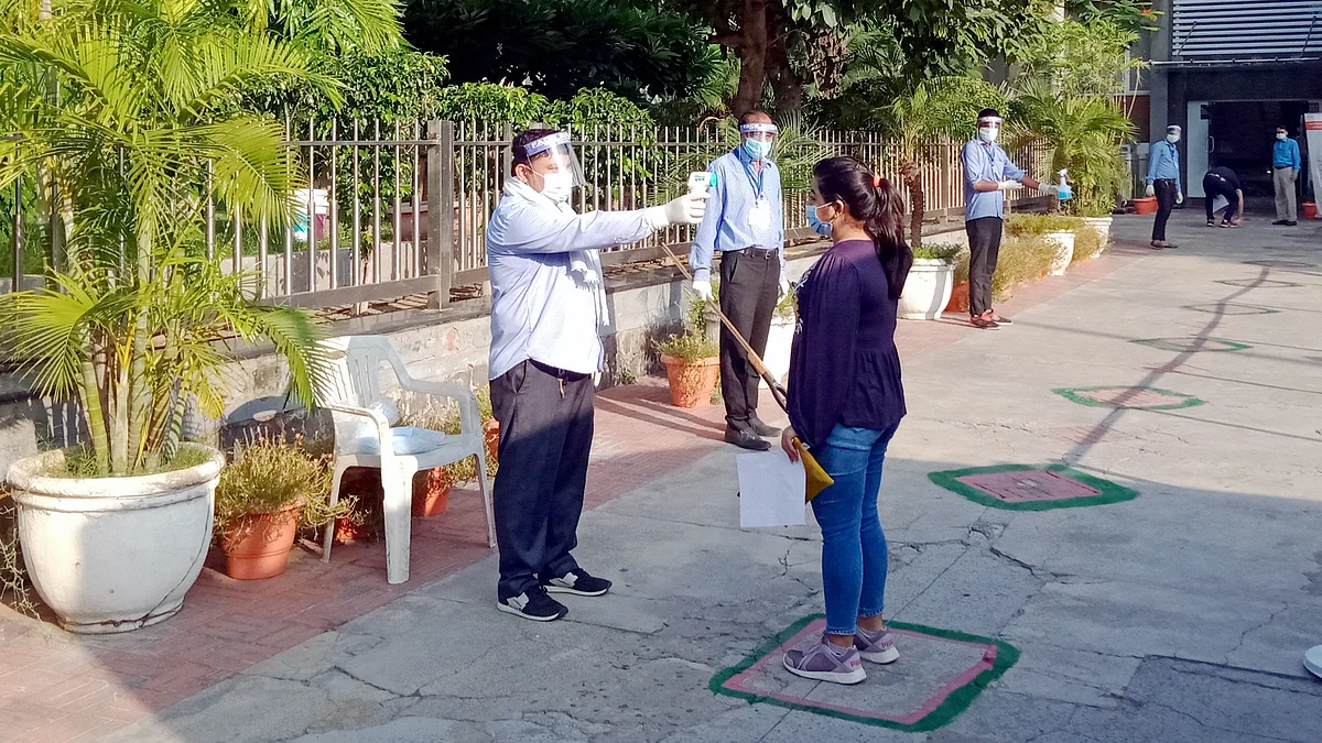 A student undergoes thermal screening as she enters an examination centre to appear for the JEE 2020 entrance papers, amid the ongoing COVID-19 pandemic, in New Delhi.