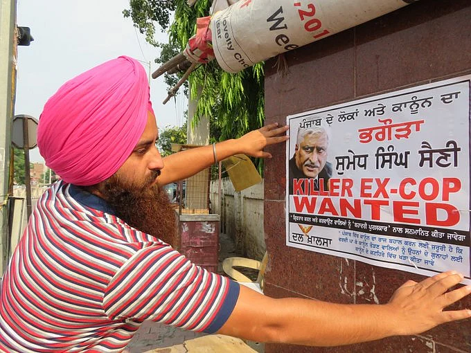 A Dal Khalsa activist puts up a ‘wanted’ poster of Sumedh Saini.