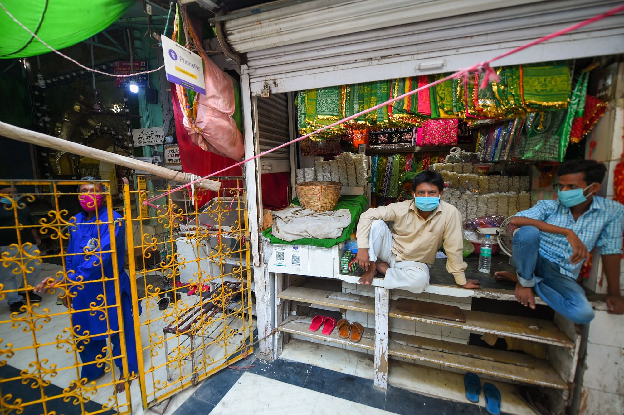 A shopkeeper waits for customers at his shop near Hazrat Nizamuddin shrine, during unlock 4.0, in New Delhi, Saturday, 5 September, 2020. The mausoleum of Muslim saint Hazrat Nizamuddin will reopen for devotees on Sunday, 6 September, with strict social distancing norms in place six months after it was closed as part of sweeping measures of check the COVID-19 pandemic.
