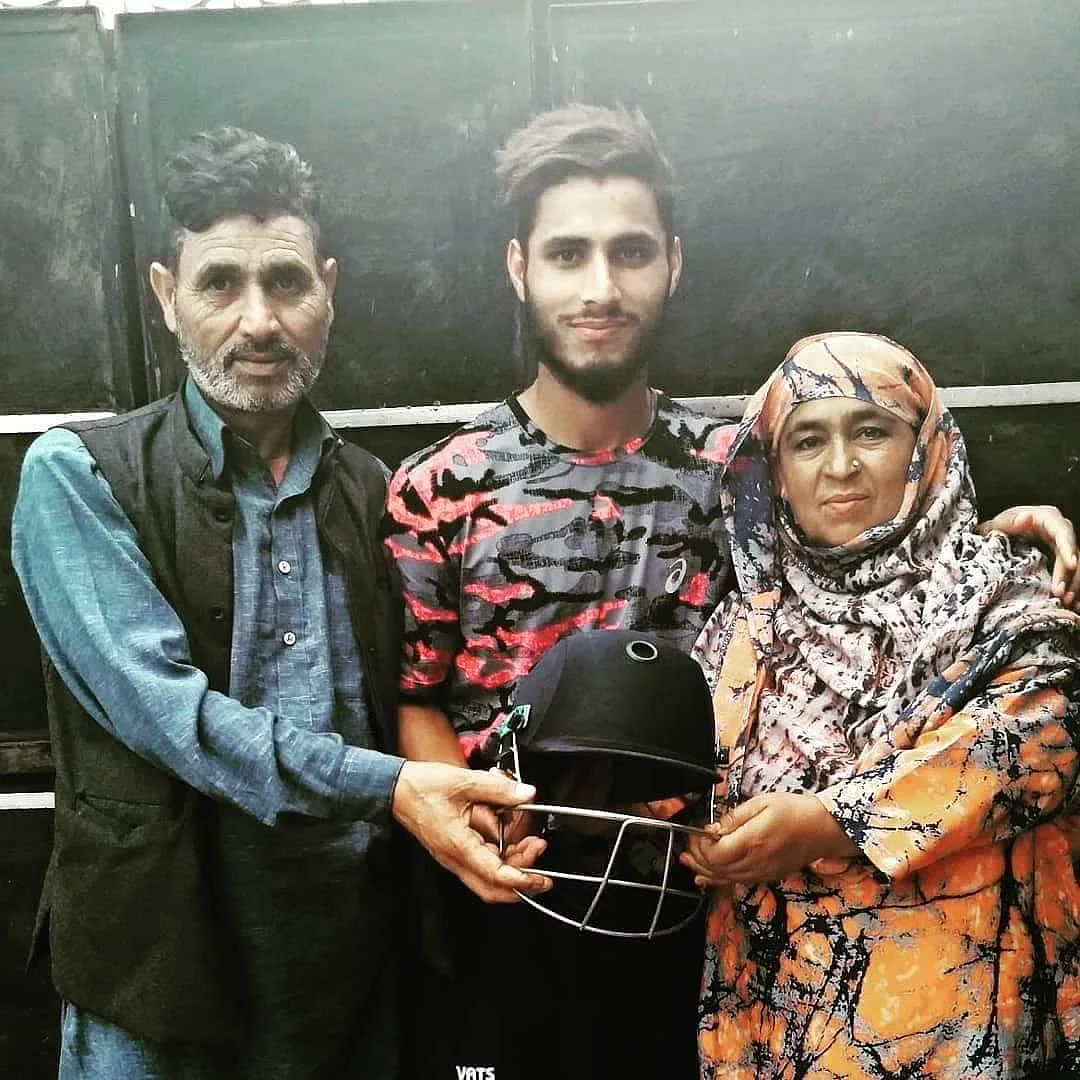 Shabir ‘Lefty’ posing with the special helmet that he received from Irfan Pathan, with his parents (on either side).