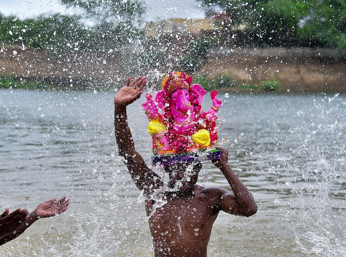 A devotee carries an idol of Lord Ganesh for immersion in the Devi Kund Sagar, during the Ganesh Chaturthi celebrations, at Bikaner.