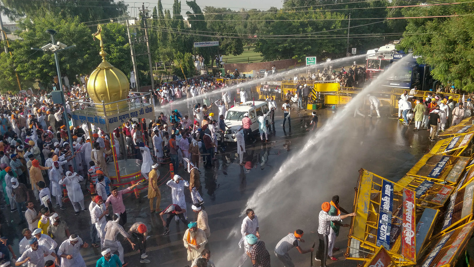 Police personnel use water cannons to disperse farmers during a massive protest against the new farm bills, in Sirsa district, Tuesday, 6 October, 2020.