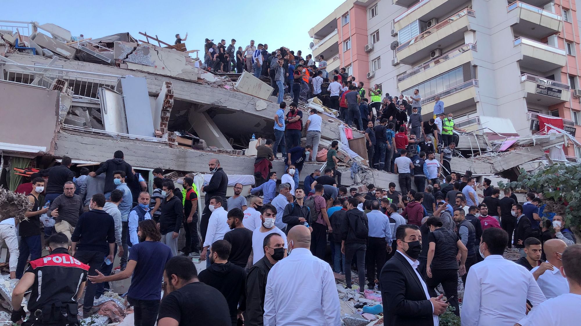 Rescue workers and local people try to reach residents trapped in the debris of a collapsed building, in Izmir, Turkey, Friday, 30 October 2020, after a strong earthquake in the Aegean Sea hit Turkey and Greece.