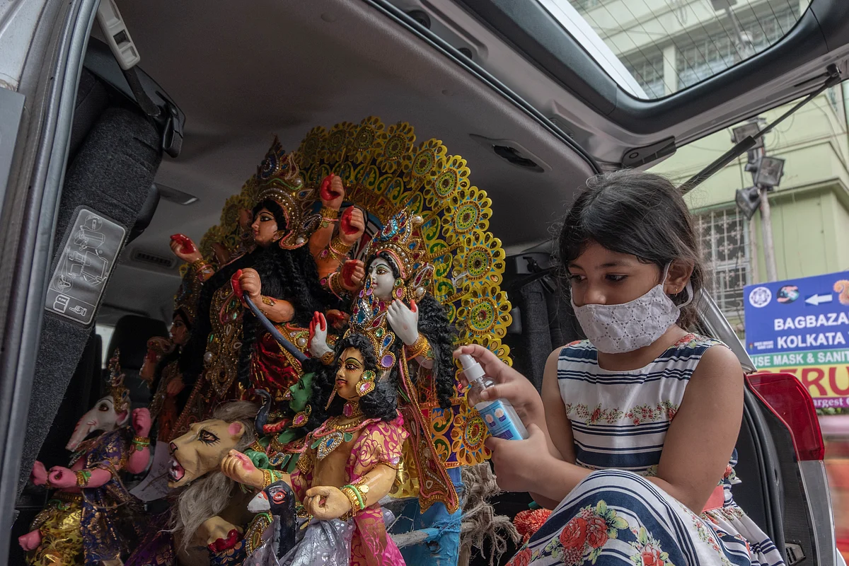 A little girl sanitises her hands before pujo celebrations in Chitpur Road, North Kolkata.