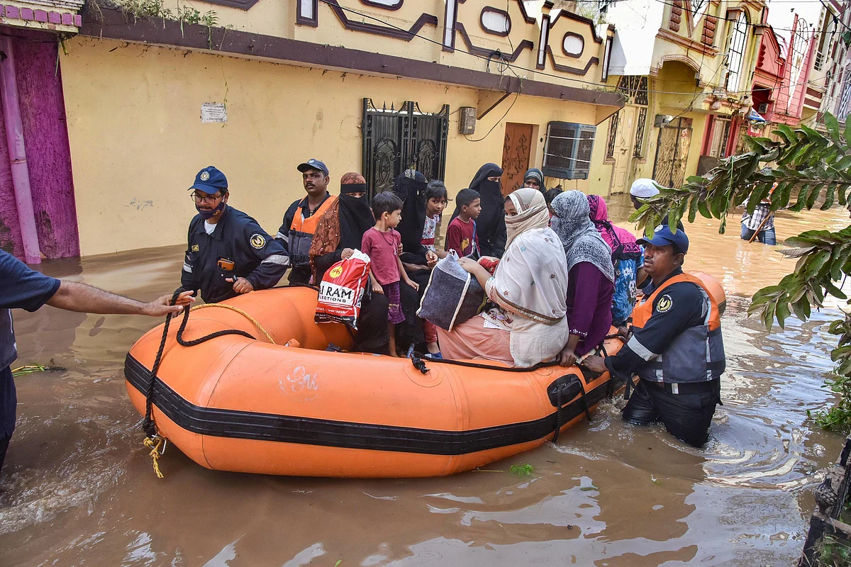 GHMC personnel carry out a rescue operation to move flood-affected people to a safer place following heavy rains, at Hafiz Baba Nagar in Hyderabad,