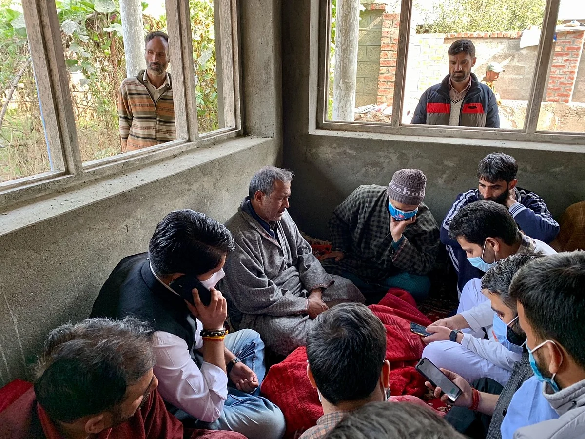 Father of Firdous being consoled by neighbors and relatives.