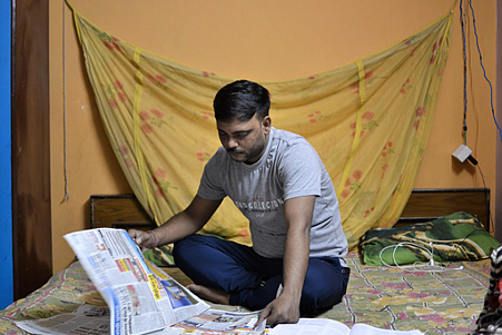 Ajay catches up on current affairs for his IAS preparation.